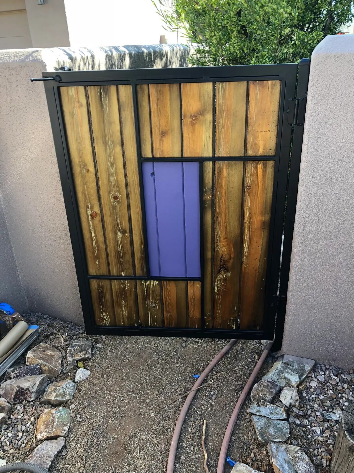 Restored exterior wood and black metal gate with purple accent in Catalina Foothills