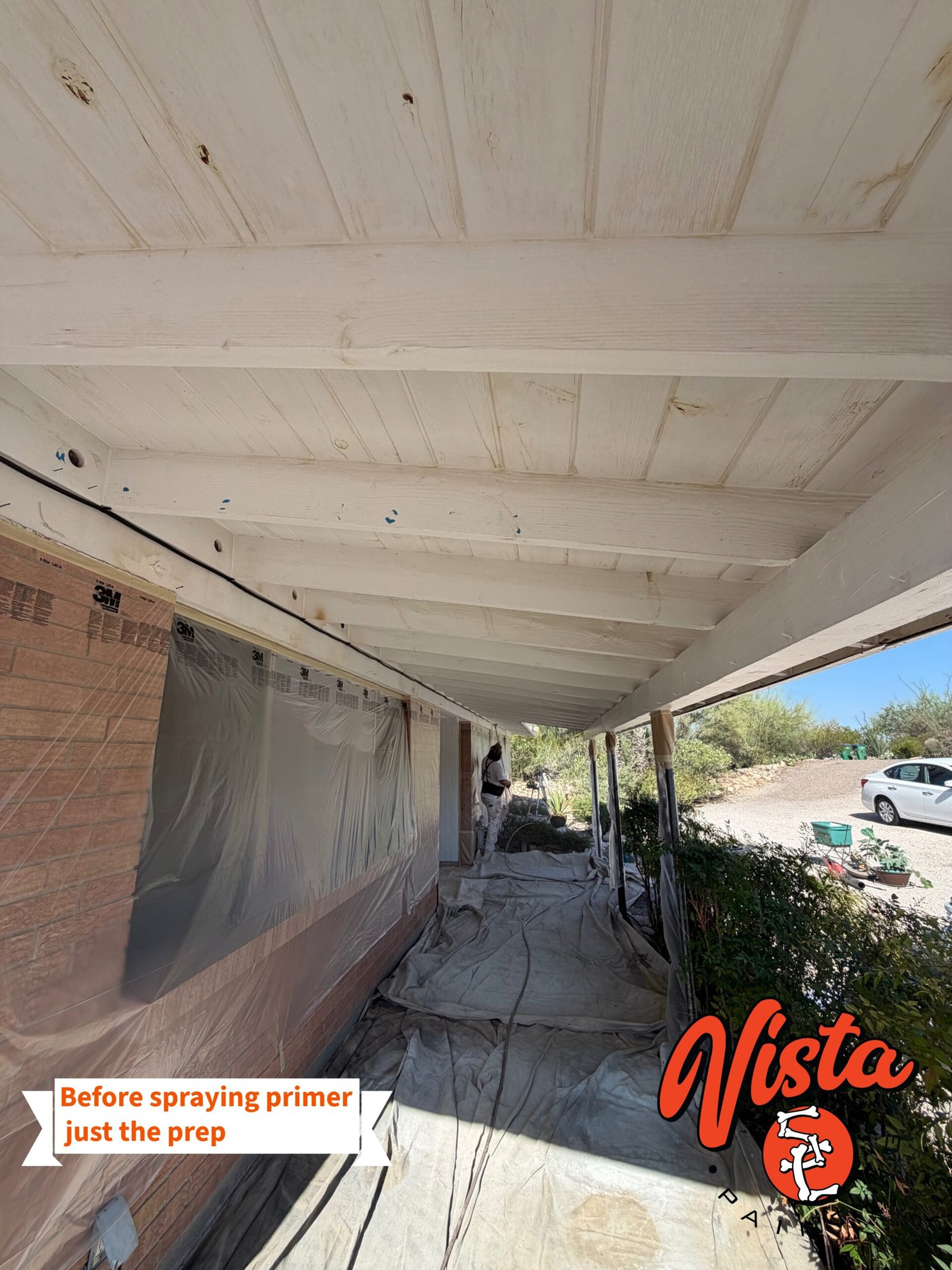 Exterior house painting preparation including masking, covering windows, and protecting landscaping before priming a Tucson home.